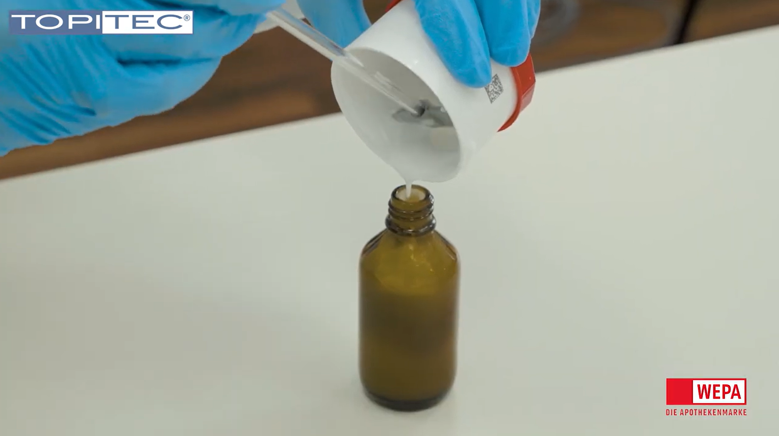Herstellung einer Nasenemulsion in der TOPITEC Kruke Flüssigkeit wird aus der Kruke in einen Glasbehälter geschüttet.