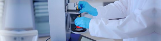 Eine Apothekerin in blauen Handschuhen zeigt, wie man den Topitec benutzt.